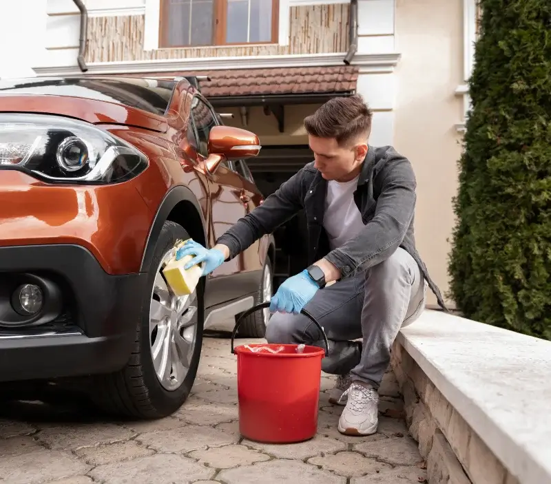 Lavage auto à domicile Sainte-Sabine-sur-Longève : professionnel intervenant sur un véhicule